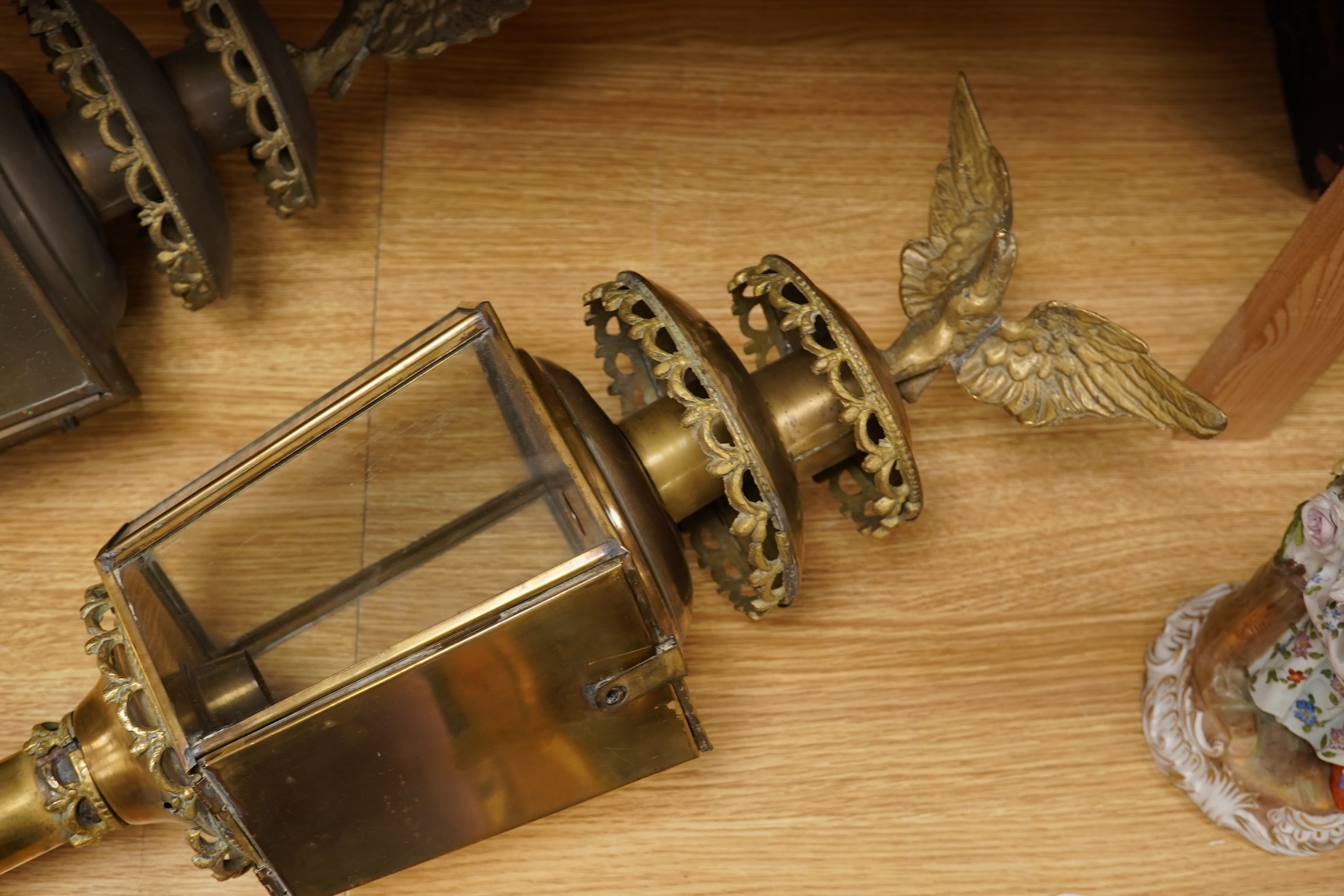 A pair of brass coaching lamps with eagle mounts, 75cm high